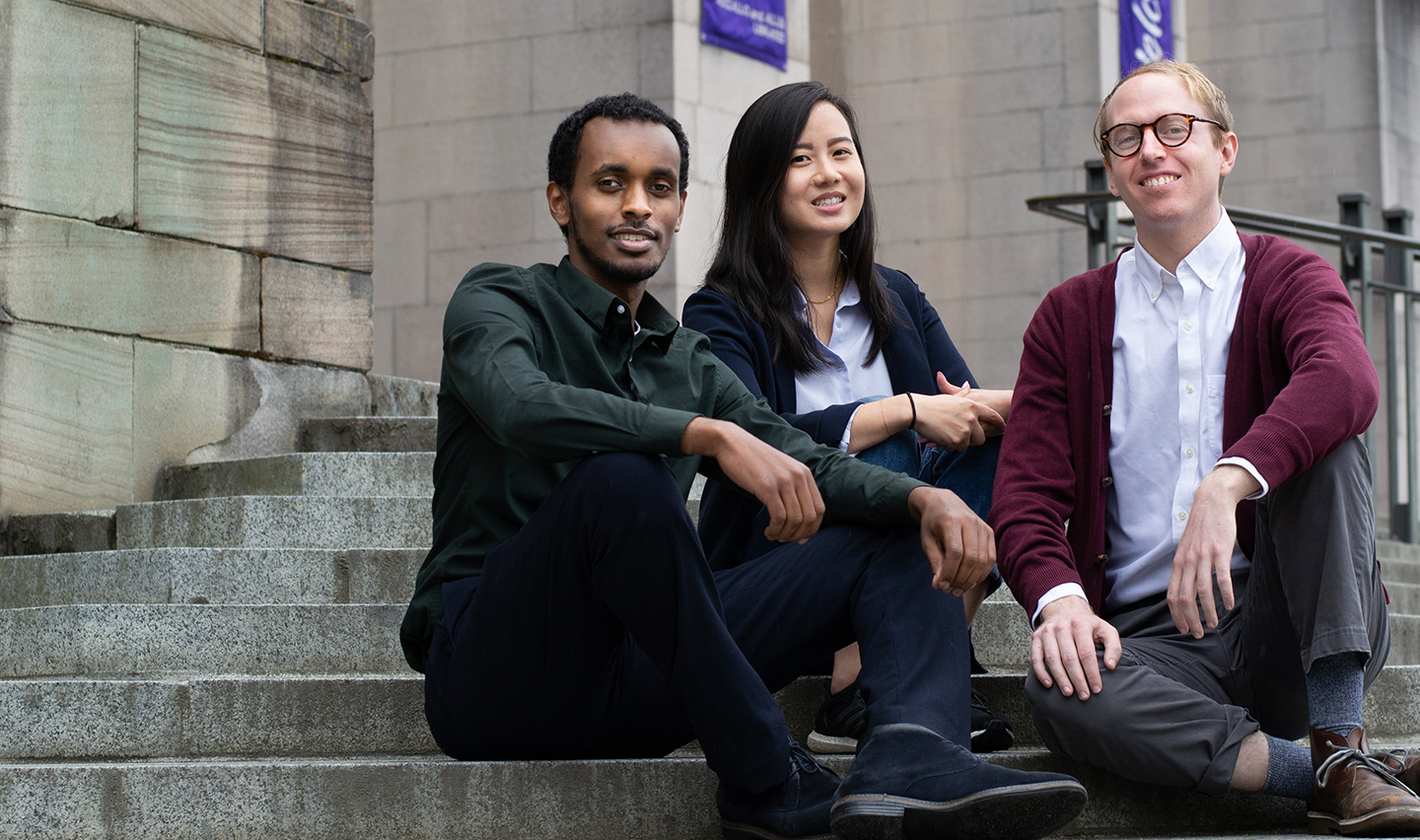 MSIM ’19 graduates Amir Ali, Tiffany Ku and Kevin McCraney seated on the steps of Suzzallo Library