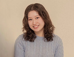 Mia McDunnah, smiling and wearing a gray sweater.