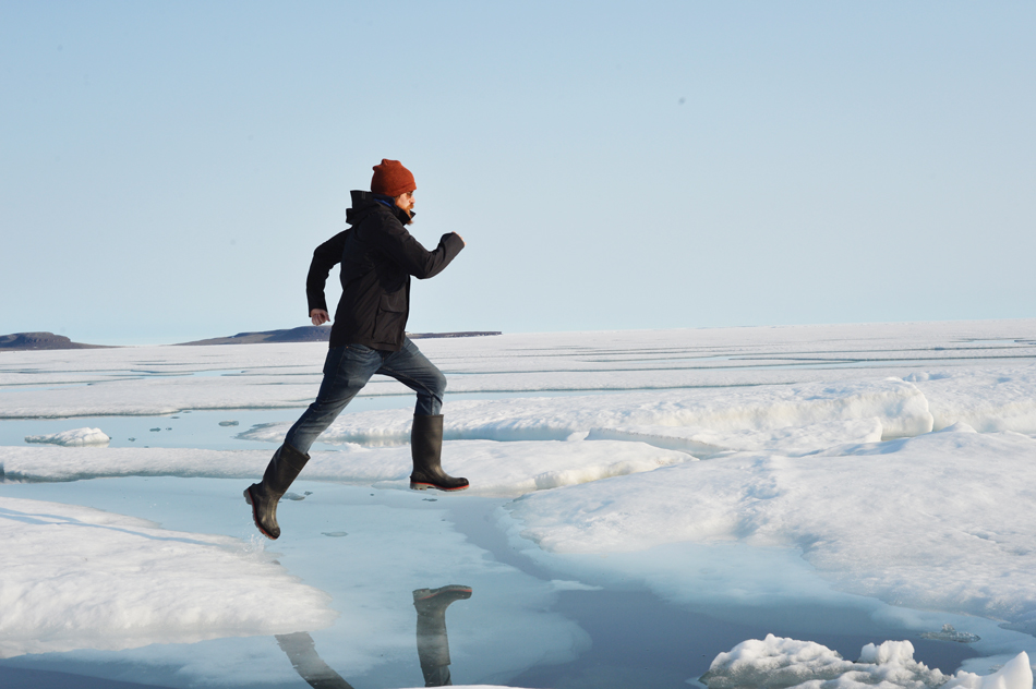 Jason Young leaps across the ice while doing research in the Arctic.