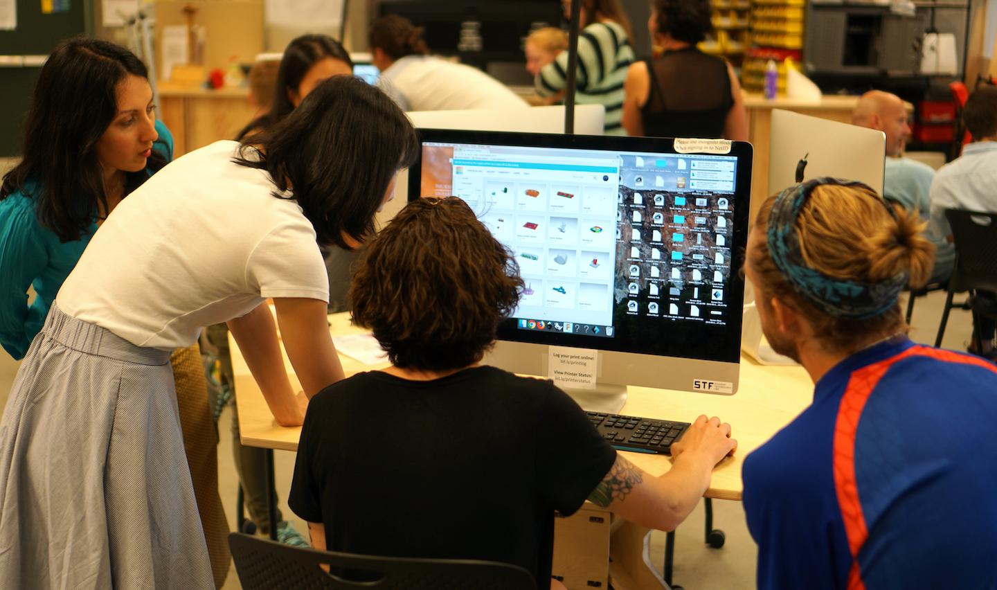 Students gathered around a computer in a classroom