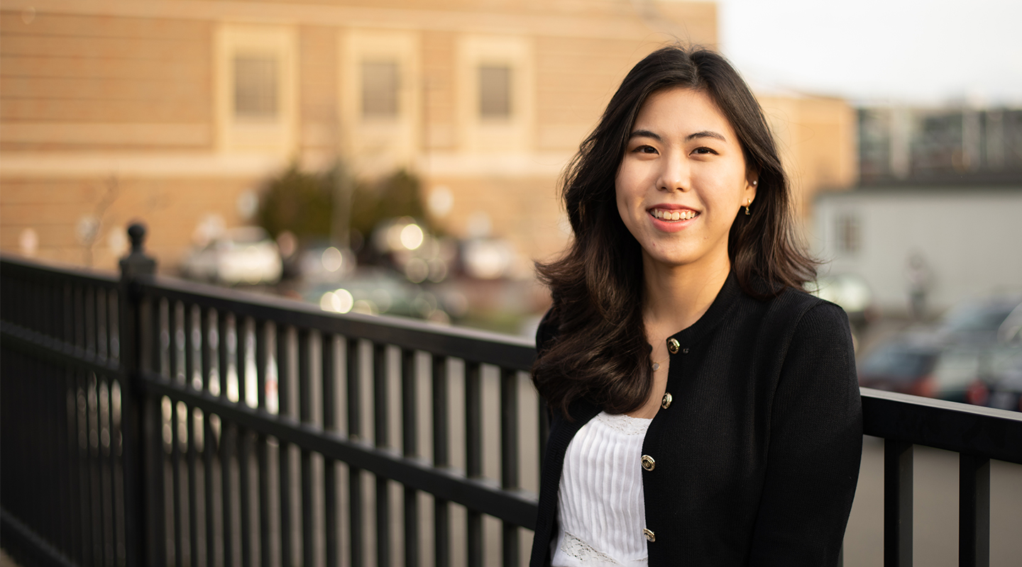 Photo of Hyeyoung Ryu, a graduate student at the University of Washington, who is from Korea. She wears a black cardigan and is smiling.