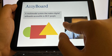 A user demonstrates the A11yBoard touchscreen interface.