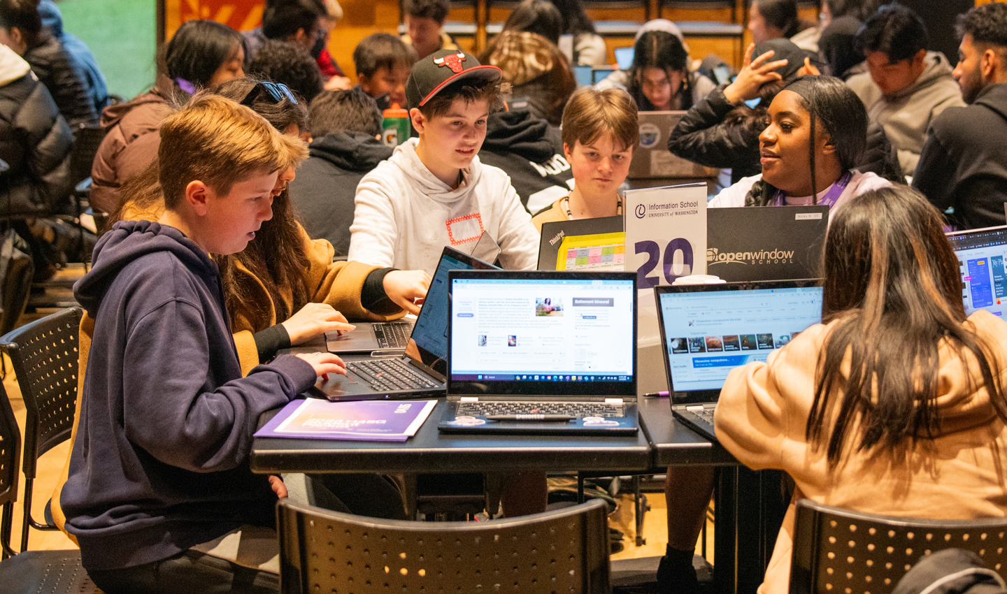 A student mentor helps kids at the Hack for Social Good hackathon