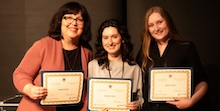 Three students holding Capstone Award certificates