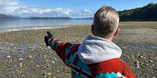 A volunteer looks out over a rocky coastline.