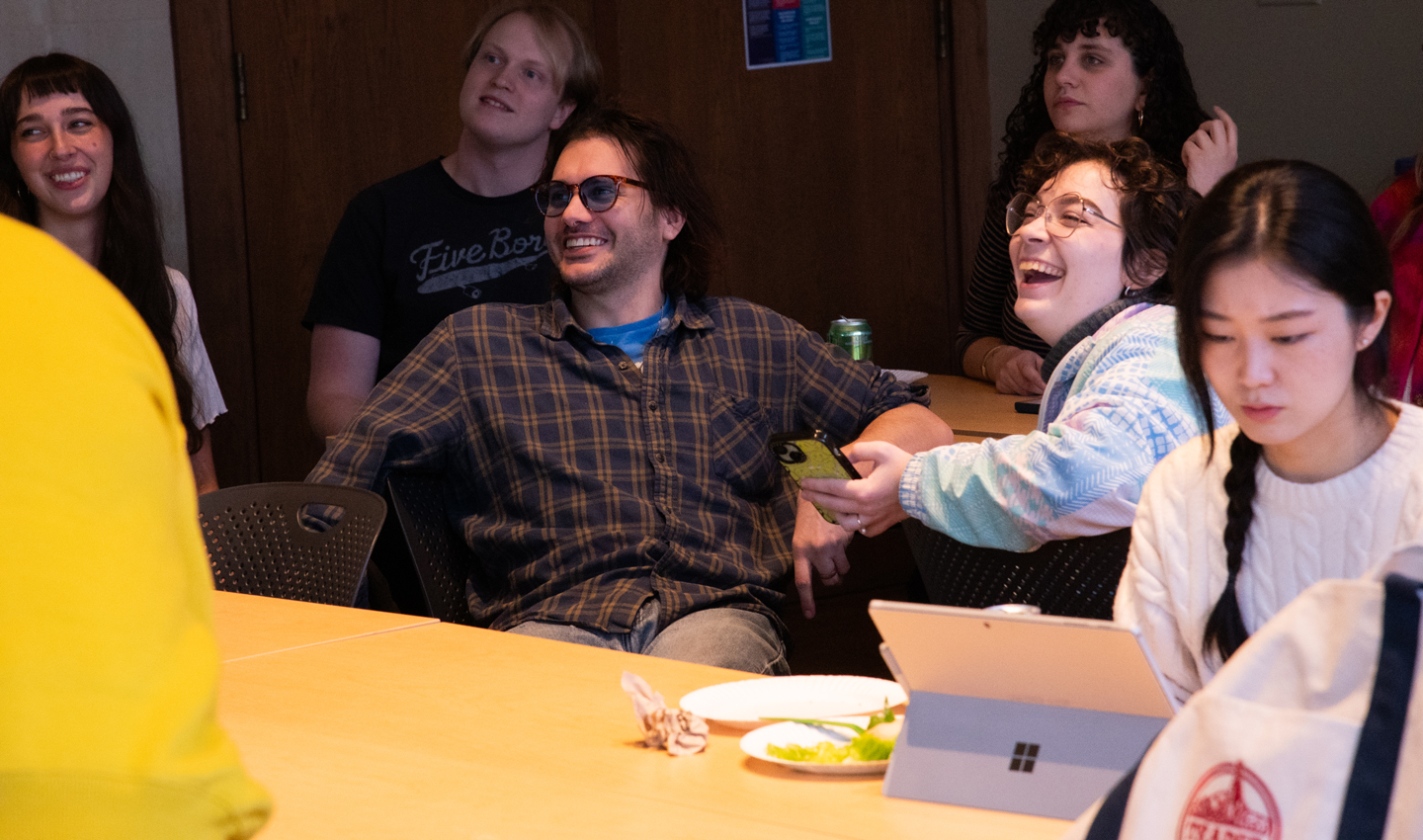 A woman and a man laugh while seated