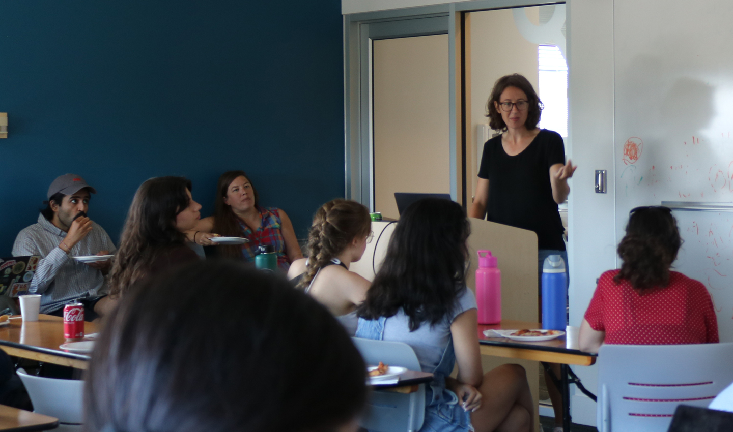 An instructor speaks to a group of students in a classroom