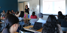 An instructor speaks to a group of students in a classroom