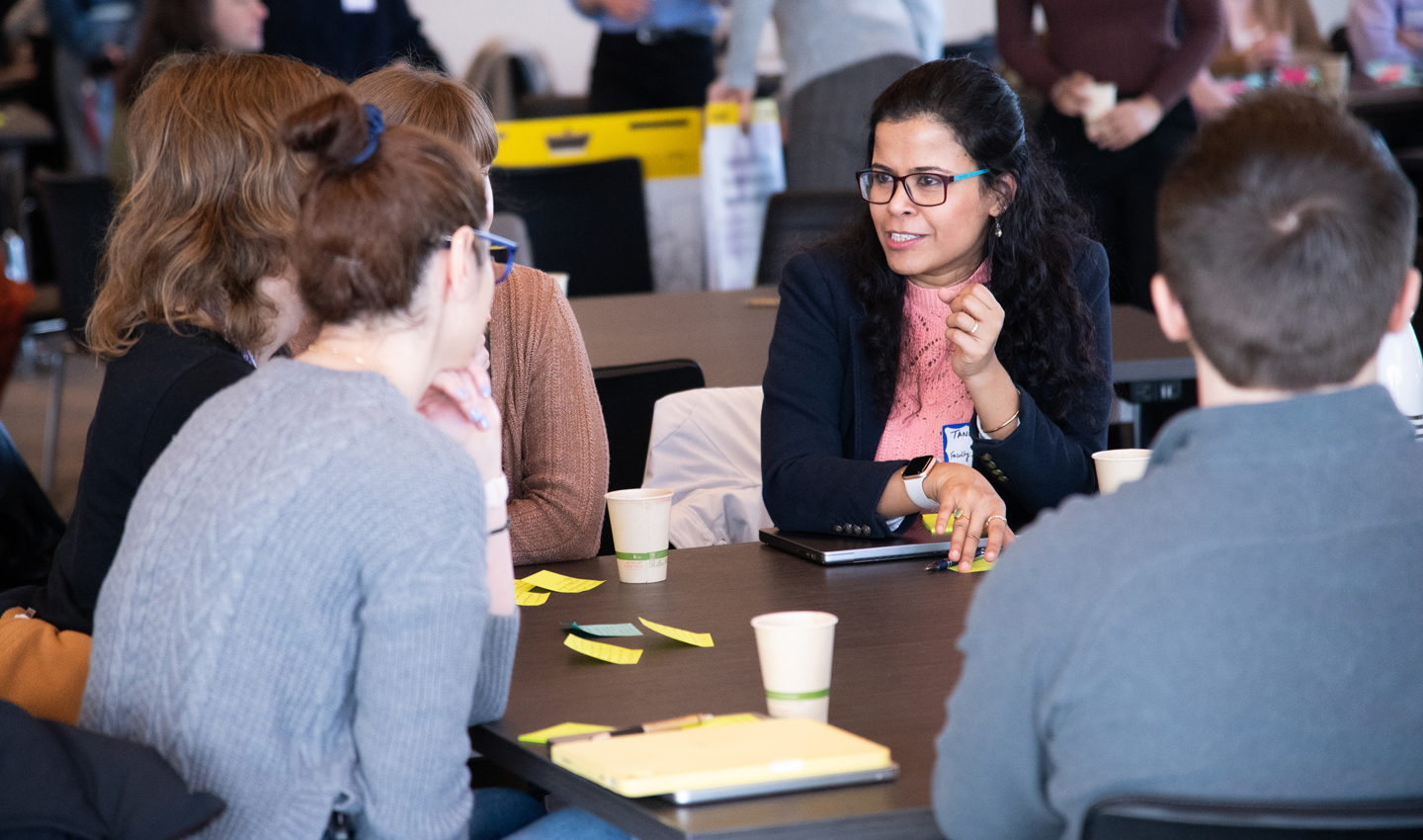 Tanu Mitra speaks with students while seated
