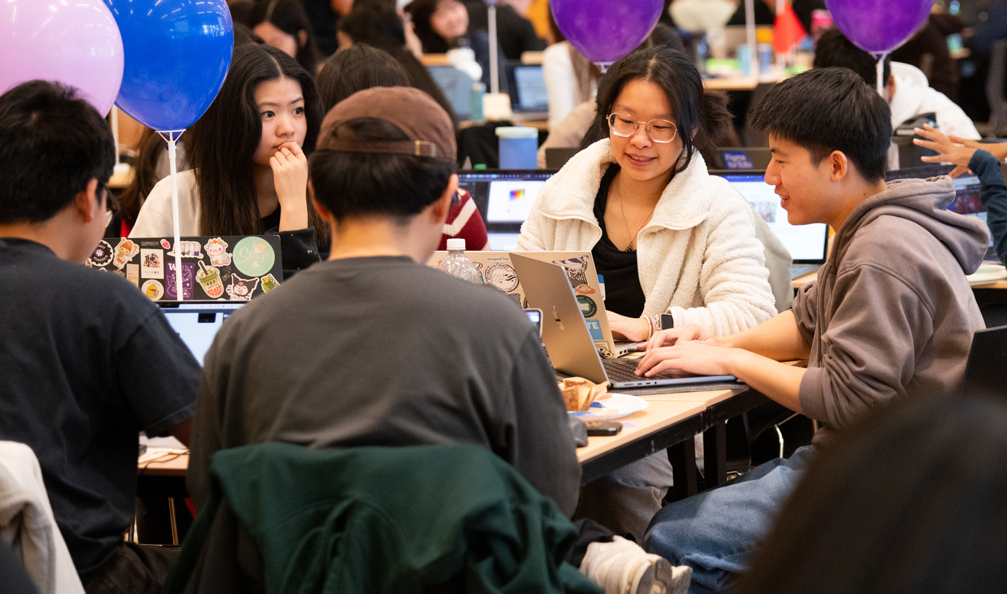 A woman and a man look at a screen together.