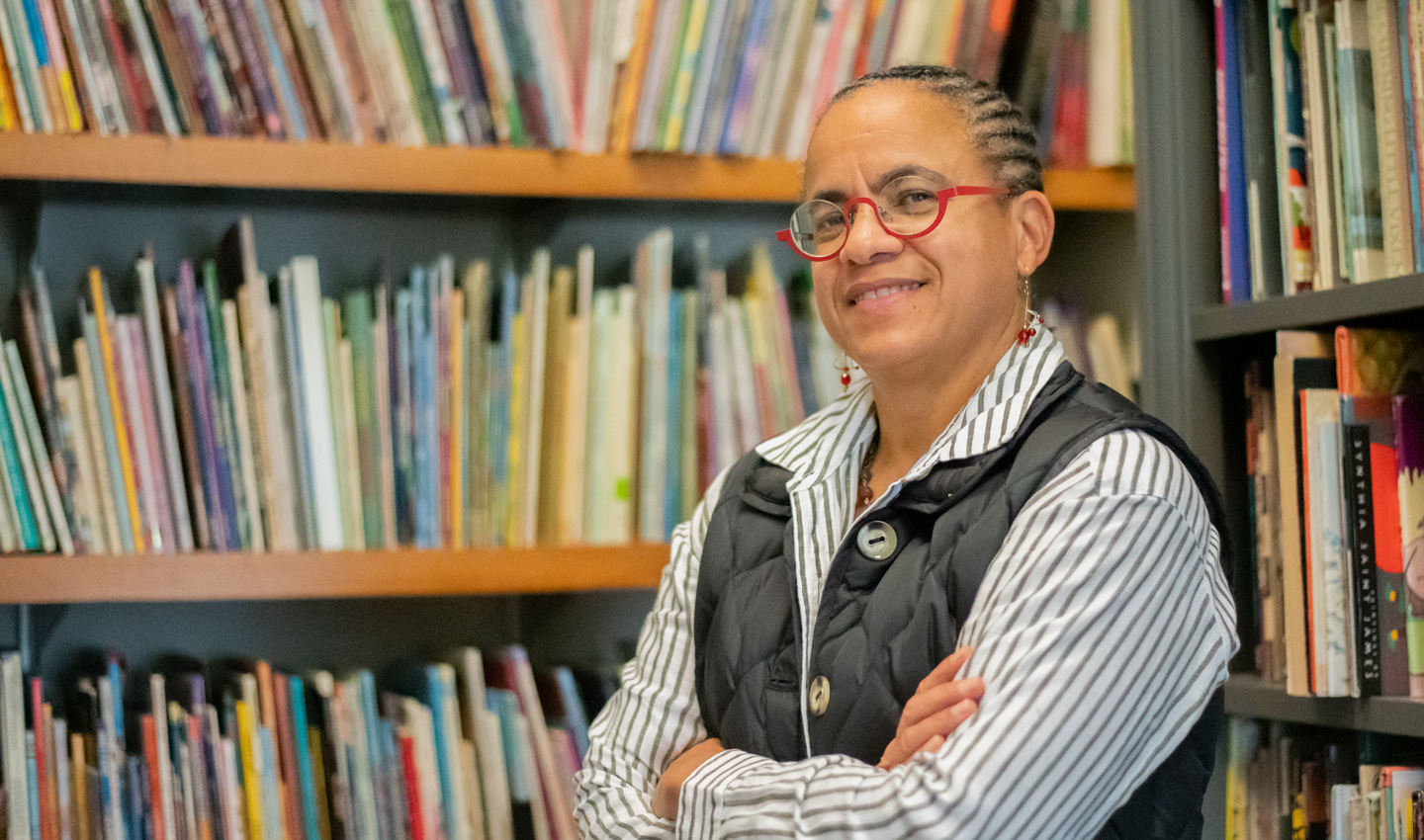 Michelle Martin, surrounded by bookshelves full of books.