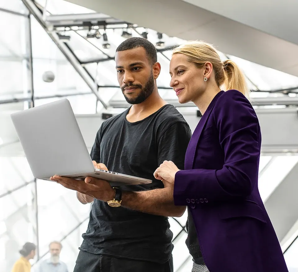 two people looking at a laptop