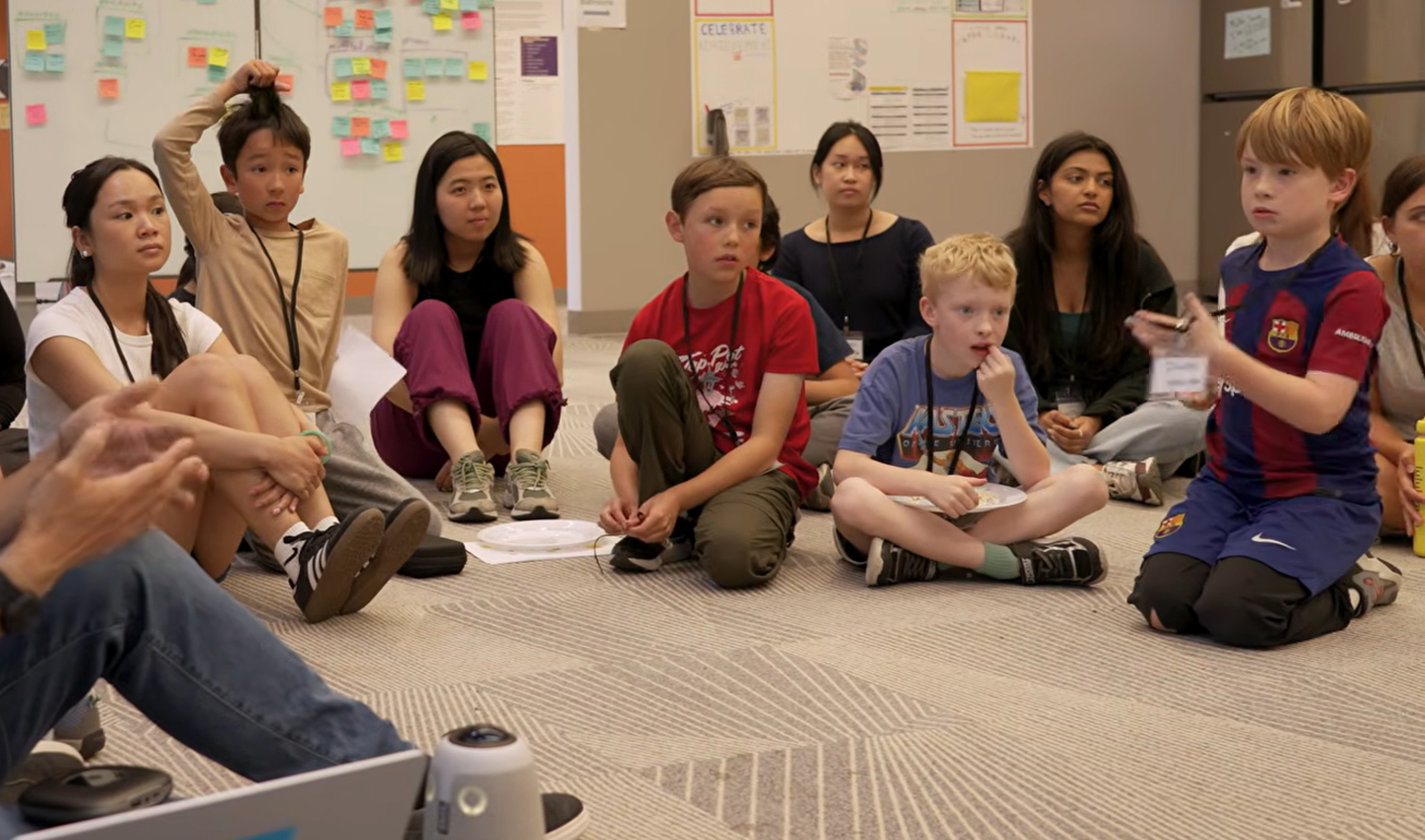A group of children gathered in a circle on a floor.