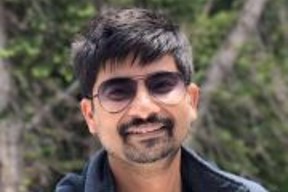 Indian man standing outside with sunglasses on