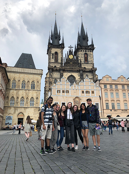Students stand in front of a monument in Prague.