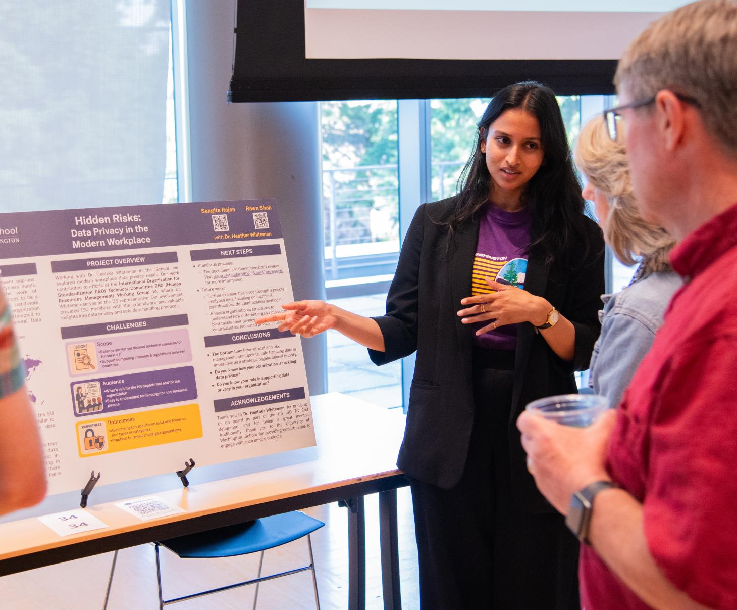 Student presents project to two event attendees