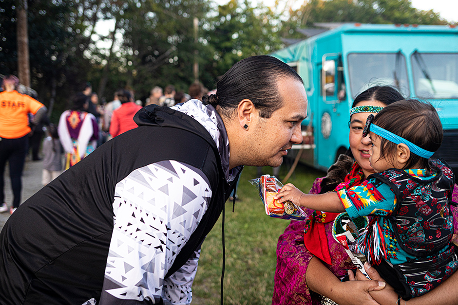 Iisaaksiichaa greets his sister and nephew at the powwow at Daybreak Star Cultural Center in Seattle.