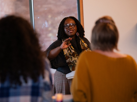 Tracie D. Hall speaks at a lectern.