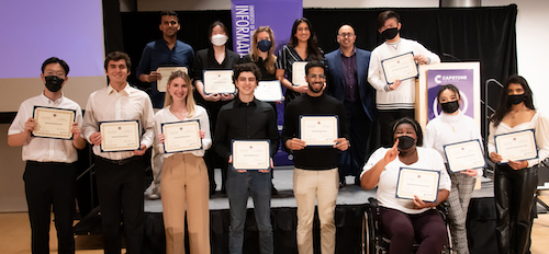 A group of students gathered around Dean Anind K. Dey, holding award certificates