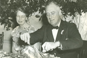 Franklin and Eleanor Roosevelt carve a Thanksgiving turkey.