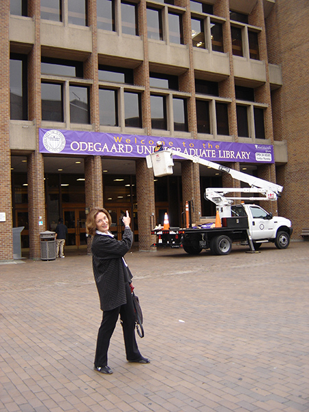 Jill McKinstry points to a sign welcoming visitors to Odegaard library.