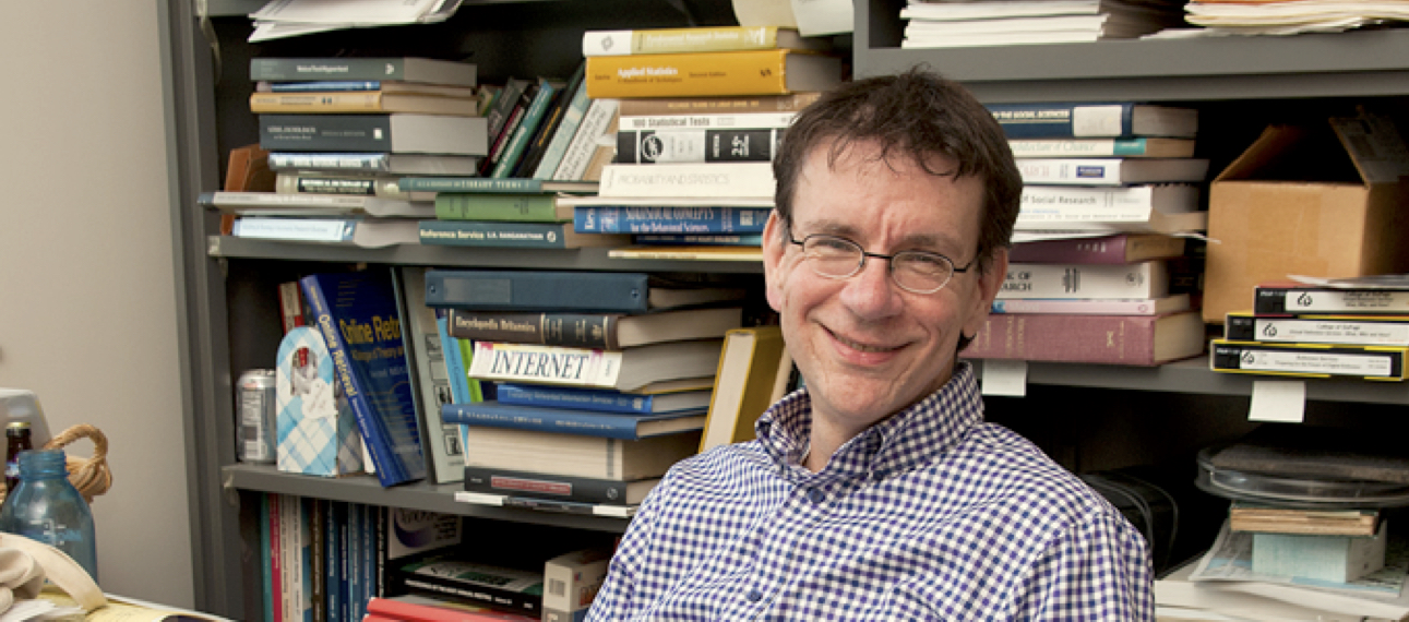 iSchool Professor Joe Janes in his office with a myriad of documents laying about.