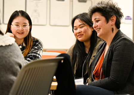 Three women in a discussion in a classroom