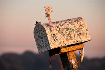 A mailbox sits atop a post outdoors.