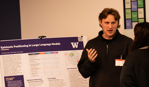 Ph.D. student Nicholas Clark speaks to a visitor about his research.
