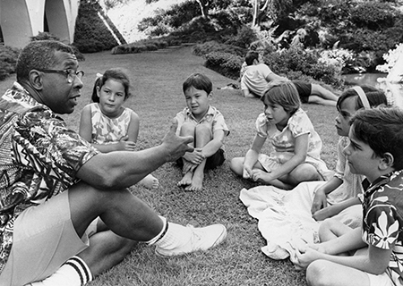 Spencer Shaw speaks with a group of children