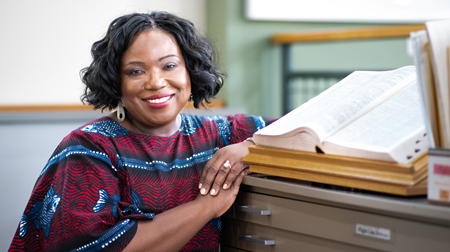 Tracie Hall poses next to an open book.