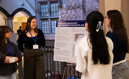 Four women discuss a poster.