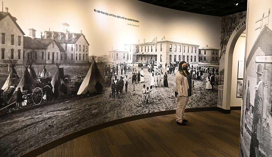 Naomi Bishop walks through an exhibit on the history of Indian boarding schools at the Heard Museum in Phoenix.