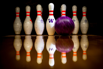 A bowling ball and UW-branded pins