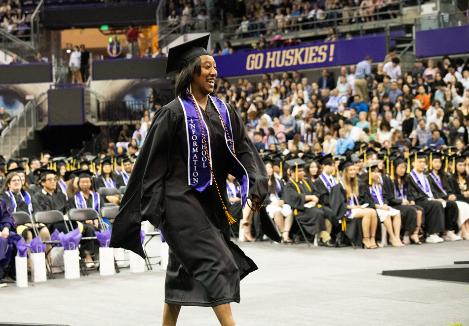 Dev Wilder walks to the stage to accept the Ruth Worden Award for Student Excellence in Library and Information Science during the iSchool Convocation ceremony on June 3.
