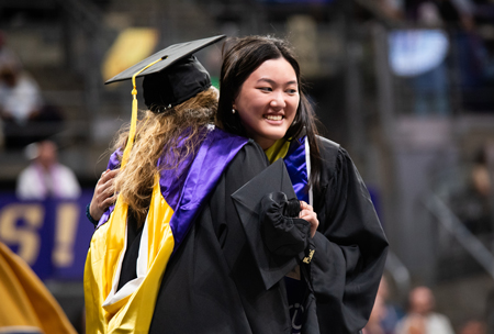 Ali Lo smiles as she hugs a faculty member.
