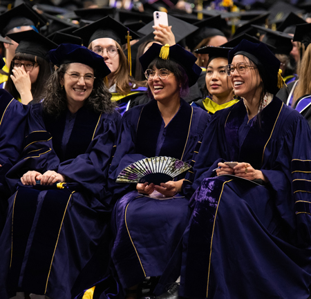 Ph.D. graduates Rotem Landesman, Itza Carbajal and Sarah Nguyen share a laugh while seated.