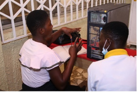 Two young people examine a computer.