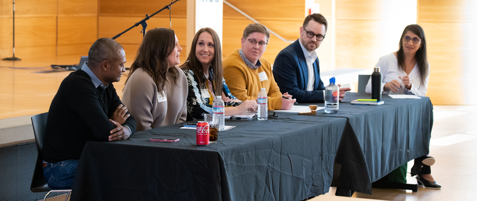 Six people seated at a table, facing an audience.