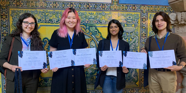 Holding their certificates, from left, are Ayse Gursoy, Victoria Chang, Ria Antony, and Joe Eduard Rucker. 