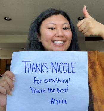 Alycia Nguyen holds a sign thanking her mentor.