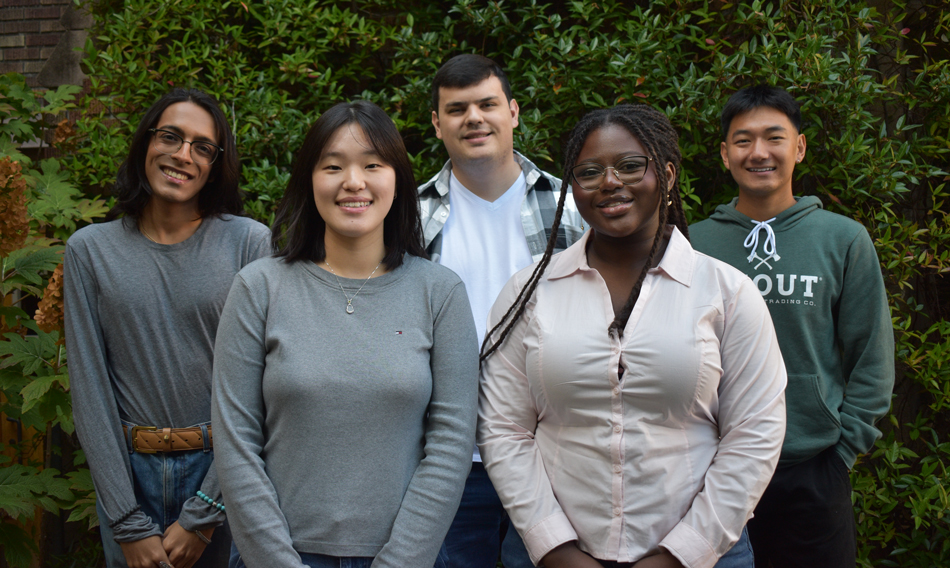 Five students stand side by side.