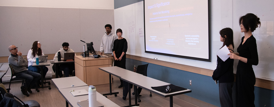 Munir Emam and Jacqueline Flynn, Charlotte Liu and Yuxin (Ellie) Wu present in a classroom.