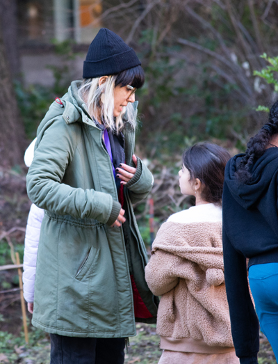 Itza Carbajal speaks with one of the children in her class during an outdoor excursion to the UW Medicinal Herb Garden.